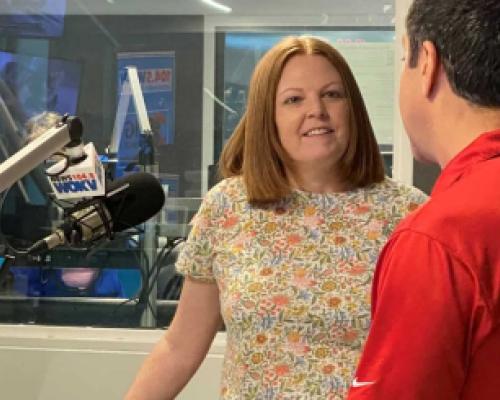Kelly Jones stands in front of the microphone in the radio studio at WOKV with Rich Jones